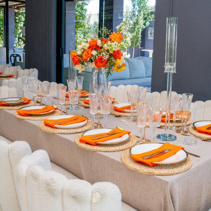 Long table setting in orange and linen